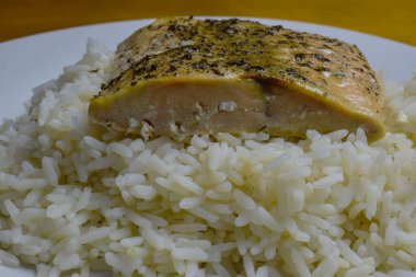   Beyaz pirinç üzerine baharatlı somon filetosu.