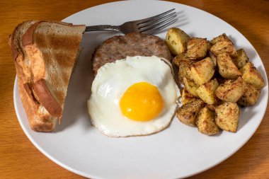 Patates kızartması ve kızarmış ekmekle servis edilen sosisli börek.
