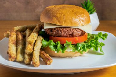 İsviçre peyniri ve brokoli kızartmasıyla servis edilen bitkisel hamburgerler.