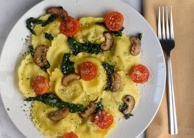  İtalyan sosisli ravioli, üstü sotelenmiş ıspanak, mantar ve domates.,
