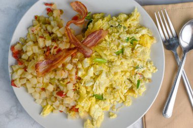 Çırpılmış yumurta, soğanlı patates kızartması, biber ve domuz pastırması.