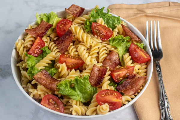 Domuz pastırmalı, domatesli ve marullu makarna salatası.