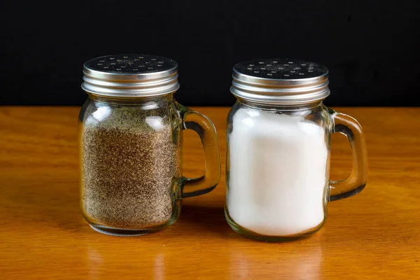 Salt Och Peppar Shakers Står Mot Svart Bakgrund — Stockfoto
