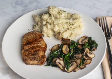  Sotelenmiş mantarlı tavuk göğsü ve yanında patates püresi ile ıspanak.