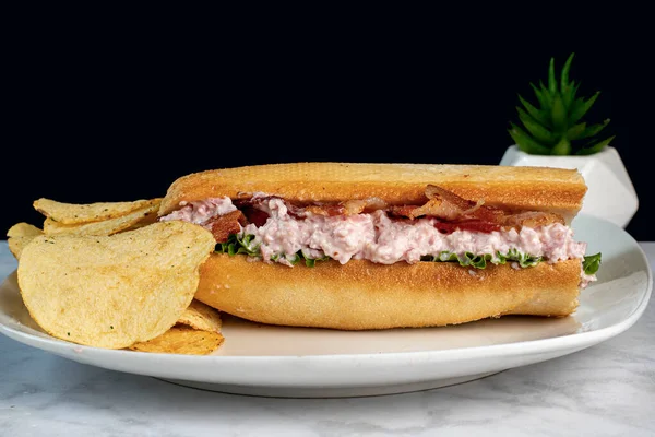 ham salad sub top with bacon  served with potato chips,