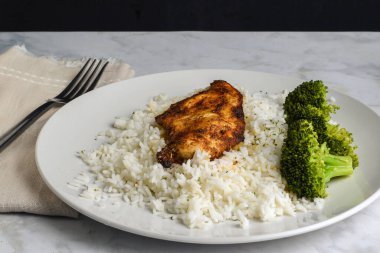 Brokoli ile servis edilen beyaz pirinçli tavuk göğsü.