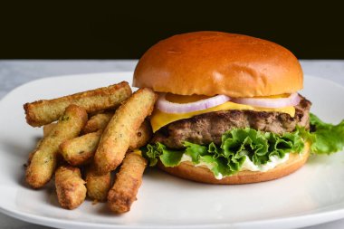 Hindi cheee burger üstü soğanlı çörek brokoli kızartmasıyla servis ediliyor., 