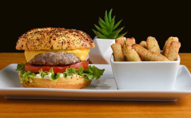 Brokoli kızartmasıyla servis edilen her şey üzerine hindi peynirli burger.,