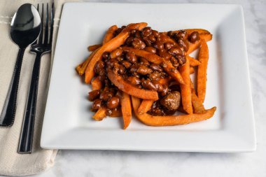Chili con carne tatlı patates kızartmasının üzerinde dinleniyor.