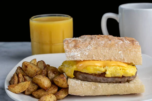 stock image  scramb;e egg  and sausage patty on ciabatta  served with home fries