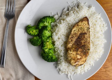 Pirinç ve brokoli ile servis edilen tavuk göğsü.