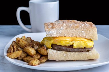 Ciabatta üzerine yağda yumurta ve sosisli börek, yanında da patates kızartması.