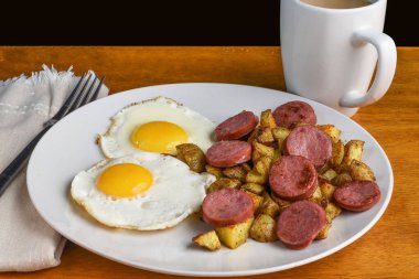 iki sahanda yumurta, patates kızartması ve sosis.