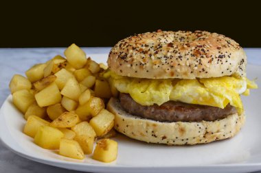 Sosis ve çırpılmış yumurtalı sandviç ve patates kızartması.,