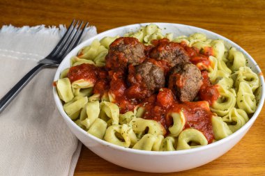 Ispanaklı tortellini köfte ve sosla servis edilir.