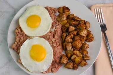Kızarmış yumurta, yanında sığır eti ve patates kızartması.,