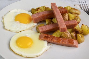 Kızarmış yumurta, konserve jambon ve patates kızartması.