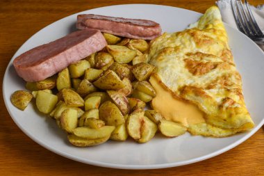 Peynirli omlet, yanında konserve jambon ve patates kızartması.,