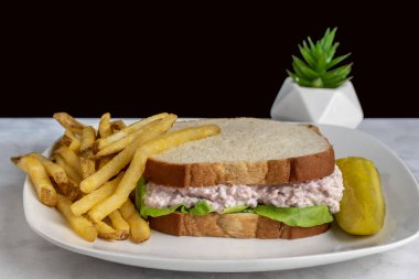 Kızarmış patates ve turşulu jambonlu sandviç.,