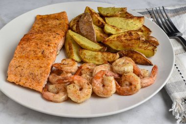 Baharatlı somon karides ve patatesle servis edilir.