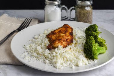 Brokoli ile servis edilen beyaz pirinçli tavuk göğsü.