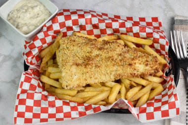 Kızarmış patates ve tarter sosuyla servis edilen mezgit., 