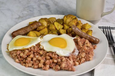 Sausages, cornbeef hash ve ev kızartması ile servis edilen sahanda yumurta,.
