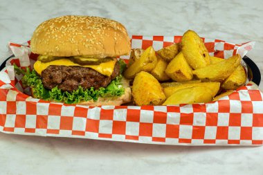  Peynirli burger üstü turşulu susamlı ekmek ve patates dilimleri.