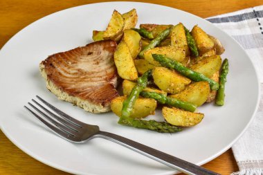 Patates dilimli ton balığı bifteği ve kuşkonmaz.
