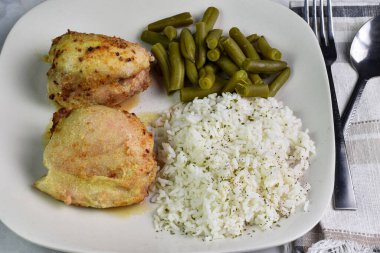 Tavuklu pilav, maydanoz ve taze fasulye ile servis edilir.