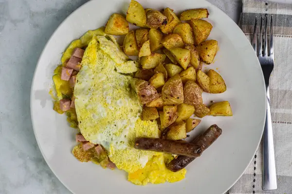 Spam Western omleti, yanında sosis ve patates kızartması.