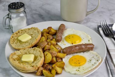 Maydanozlu sahanda yumurta, yanında patates kızartması ve kahvaltı sosisi.
