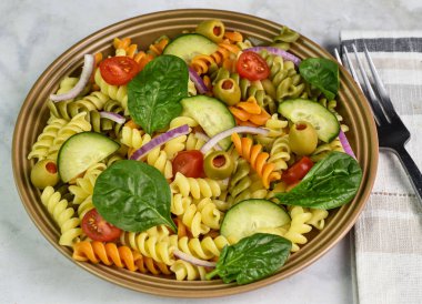 Üç renkli domates, salatalık ve zeytinli makarna.,