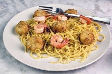 Maydanozlu spagetti üstü ve istiridye ve karidesle servis edilen peynir.,