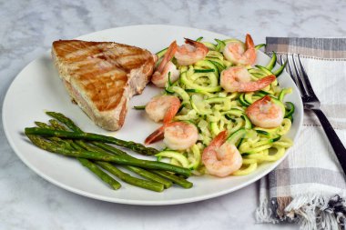 Şempanze ve kuşkonmazla birlikte kabaklı erişteli ton balığı bifteği.