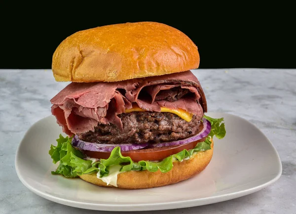 Kızarmış biftek, domates ve soğanlı çörek ile servis edilir.