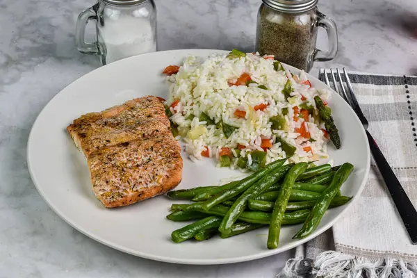 stock image baked seasoned  salmon  served with rice ., peppers and onions, and green beans