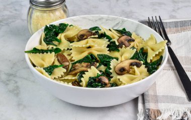 Bir kase sotelenmiş ıspanak ve mantarlı makarna., 