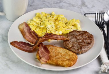 Çırpılmış yumurta, maydanozlu pastırma, sosisli börek ve kızarmış patates.