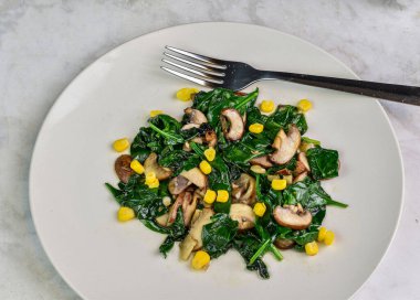 Mısır ve soğanlı sotelenmiş ıspanak ve mantar.