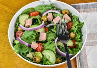 Salatalı salata, domatesli soğan ve üstüne konserve jambon.