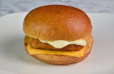 fish fillet  with melted cheese and  tarter sauce on a brioche bun  clipart
