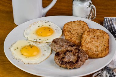 İki yumurta üstü maydanozlu patates kızartması ve sosisli börek.