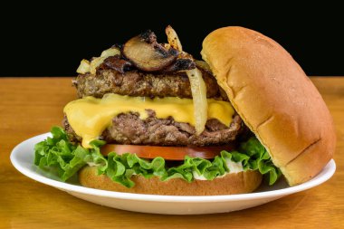 Marul ve domates soslu peynirli burger sotelenmiş soğan ve mantarlı.