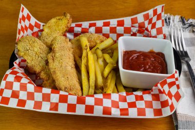 Kızarmış tavukla servis edilen parmak tavuk sepeti.