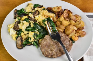 Sotelenmiş ıspanak ve soslu mantarlı omlet ve patates kızartması.