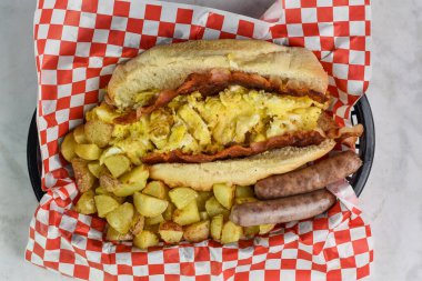 Çırpılmış yumurta ve kahvaltı yanında patates kızartması ve sosis.