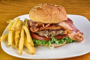 Pastırmalı hamburger, marul ve domates ve susamlı çörek.