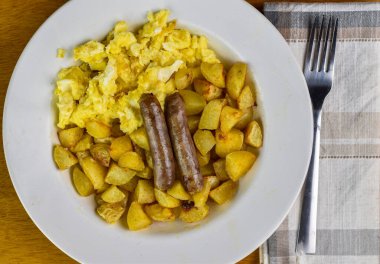Sahanda yumurta, patates kızartması ve sosis.