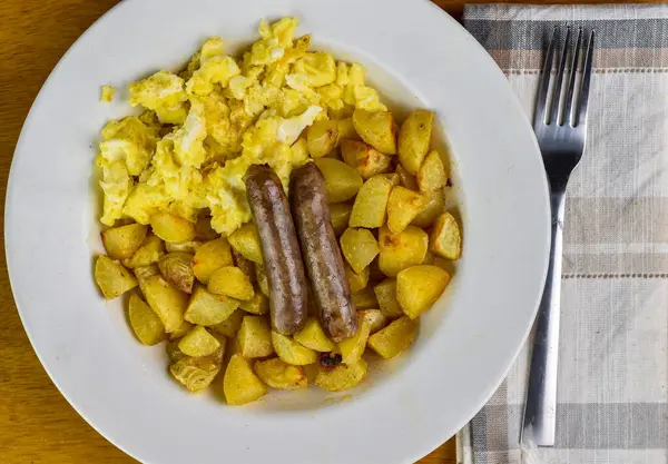 Sahanda yumurta, patates kızartması ve sosis.